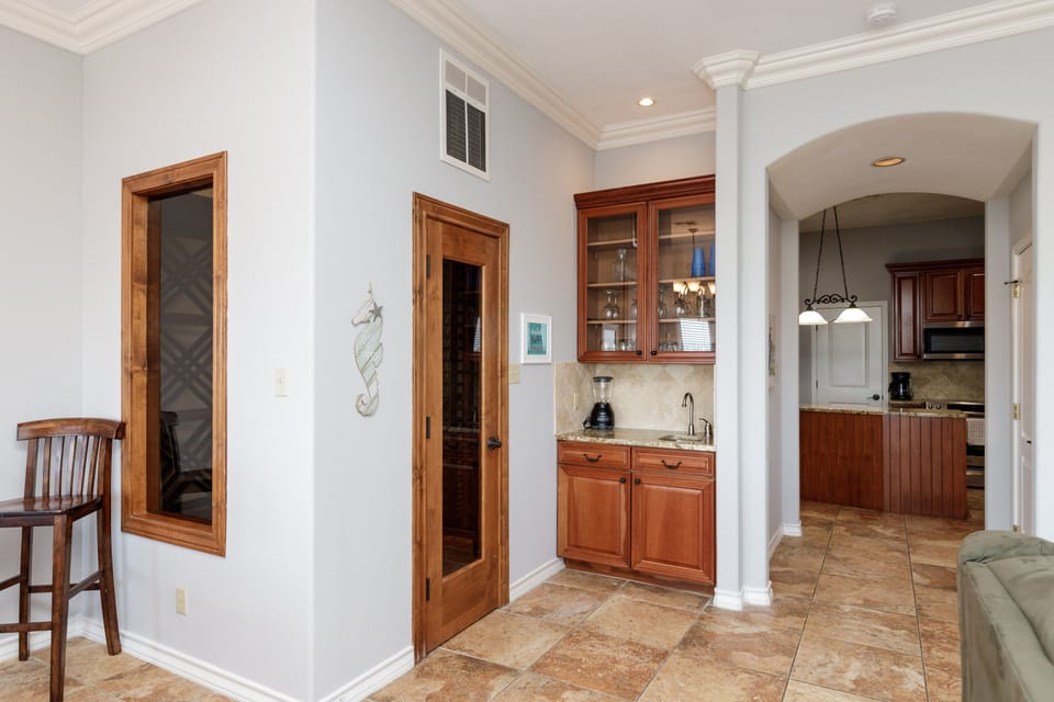 Your elegant wet bar awaits with rich wood cabinetry and granite countertops, perfect for mixing drinks while entertaining.