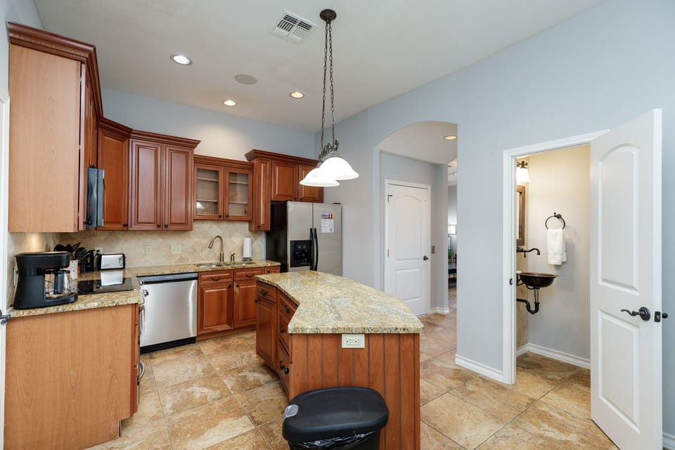 Your fully equipped kitchen features granite counters, rich wood cabinetry, and modern appliances—perfect for creating memorable meals during your stay.