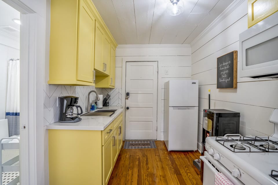 Fully stocked kitchen with all appliances and utensils.