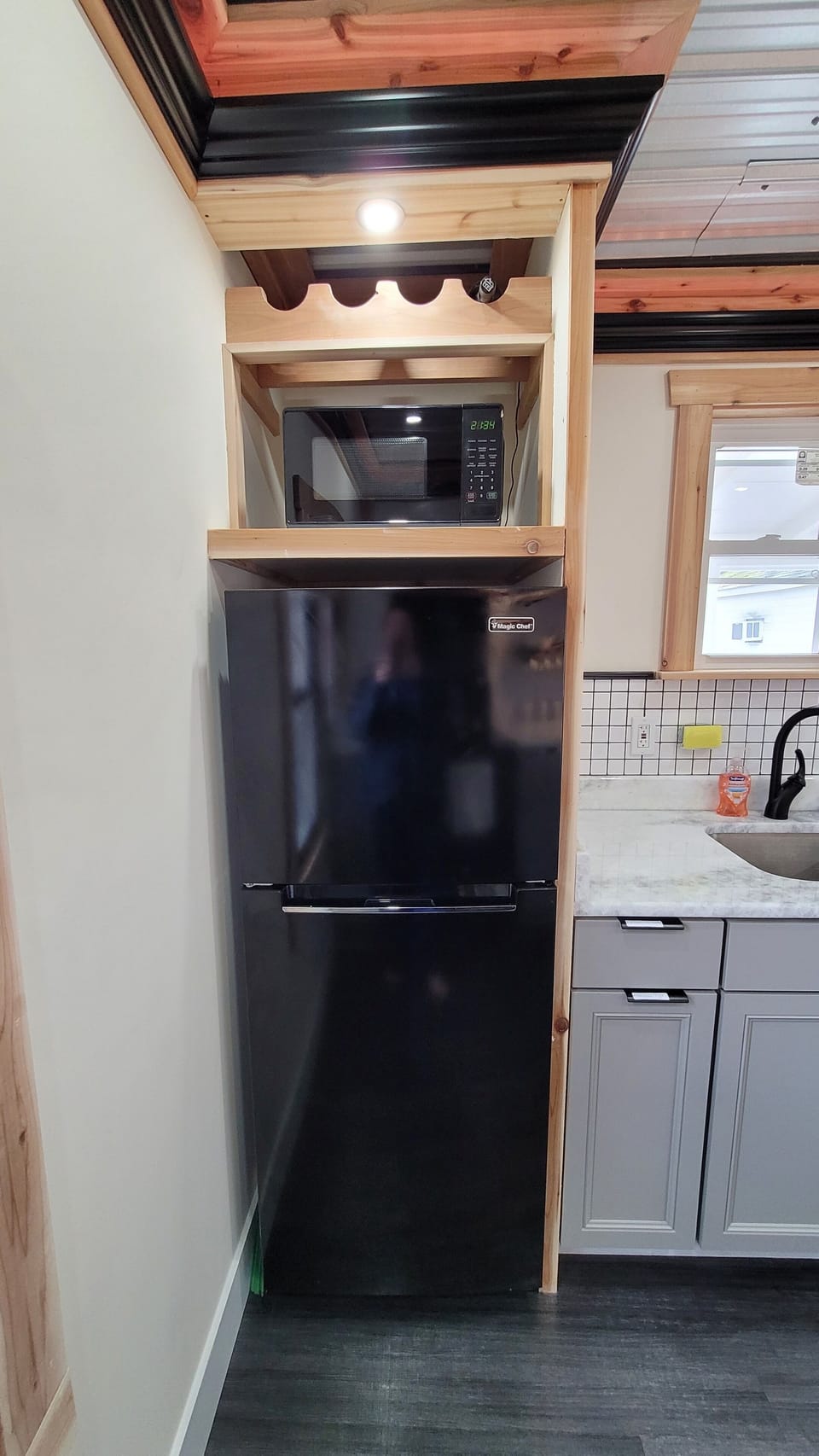 A refrigerator, microwave, and wine rack are included. 
