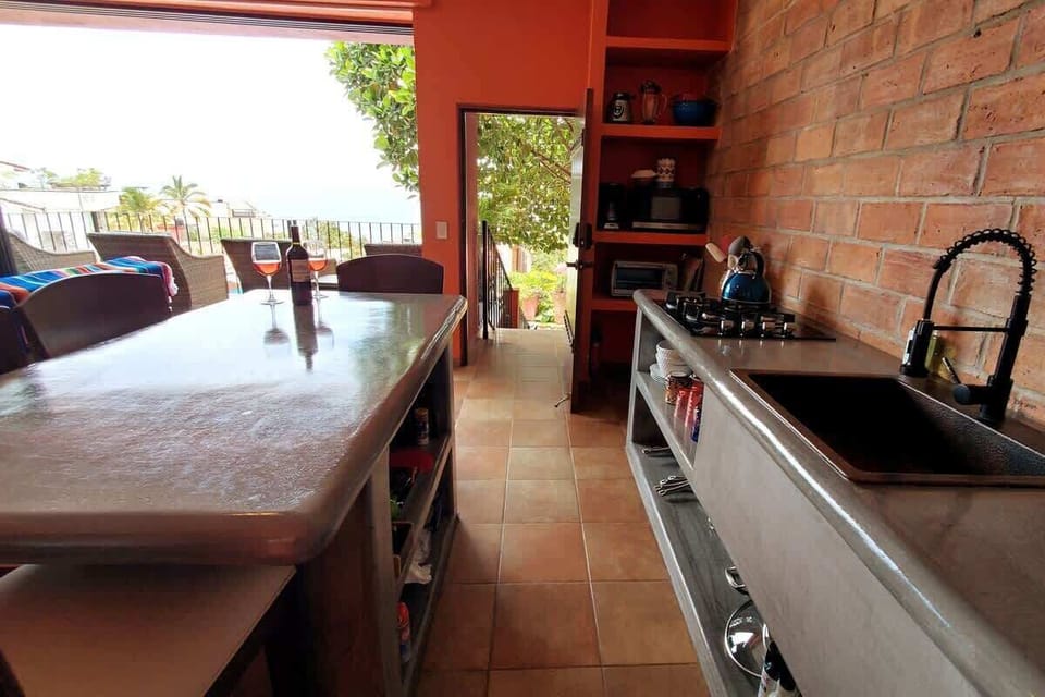Handmade concrete counters and center island, the kitchen is a great place to prepare drinks or a favorite meal. Pull up one of the handmade Parota wood stools and join in the fun.  The front door to the apartment opens onto the Living Area.