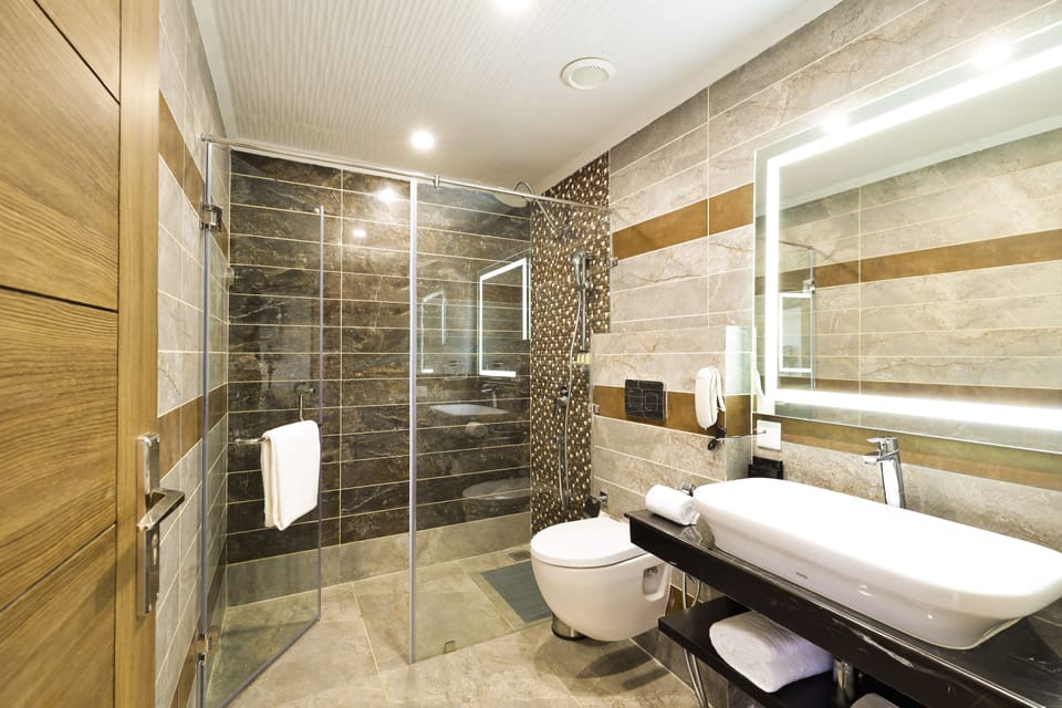 Deluxe Room with Private Balcony | Bathroom | Shower, rainfall showerhead, eco-friendly toiletries, hair dryer