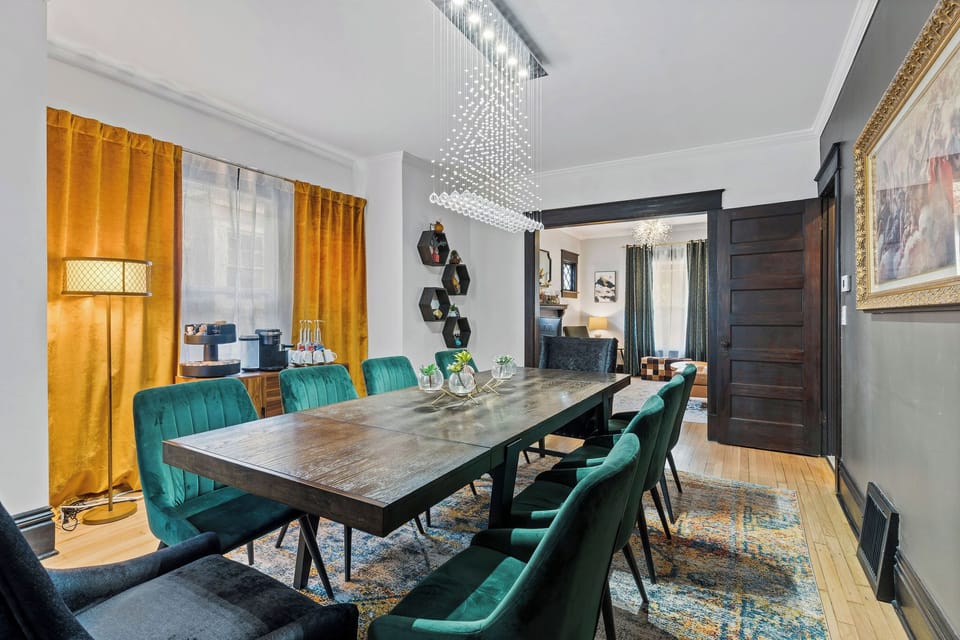 Modern-meets-classic design with deep green seating, rich wood tones, and gallery-style artwork. A beautiful place to dine and connect.