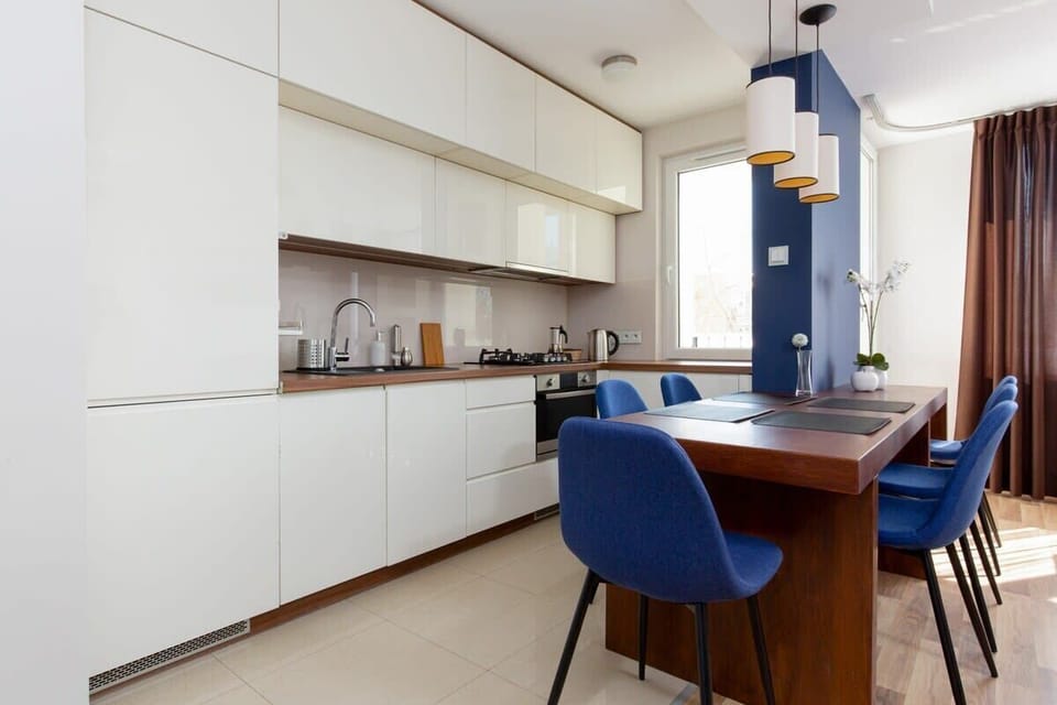 A sleek kitchen area with white cabinets and modern appliances. The layout is functional and integrates well with the rest of the space.