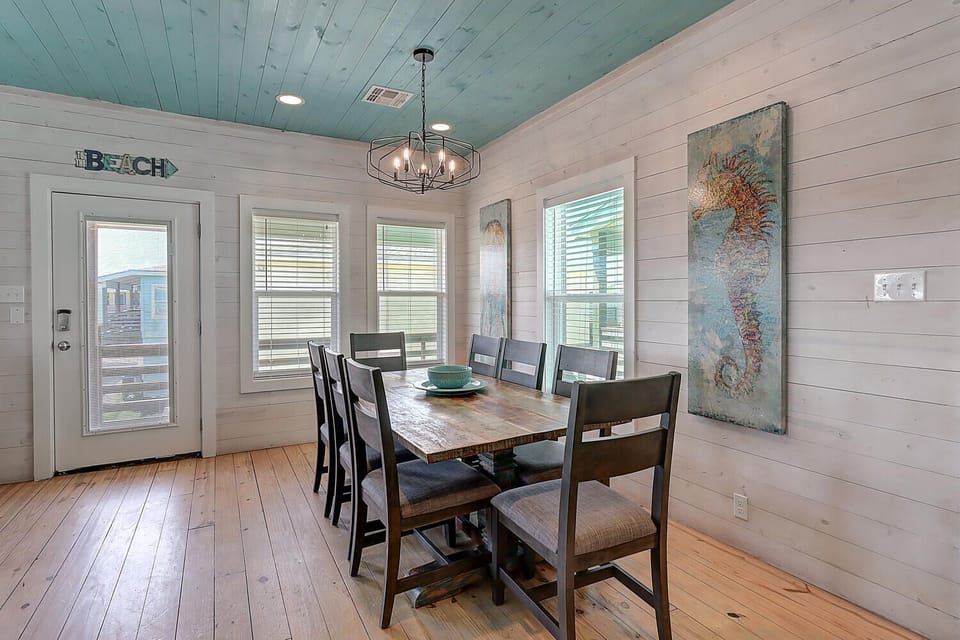 Gather around this rustic dining table where natural light streams through windows, creating the perfect spot for shared meals and memorable conversations.