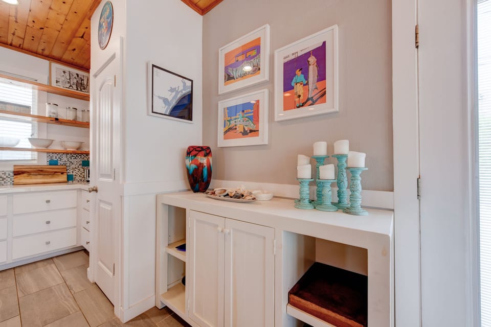 Your bright kitchen features beautiful white cabinetry, warm wood floors, and charming exposed beam ceilings that create a welcoming cooking space.