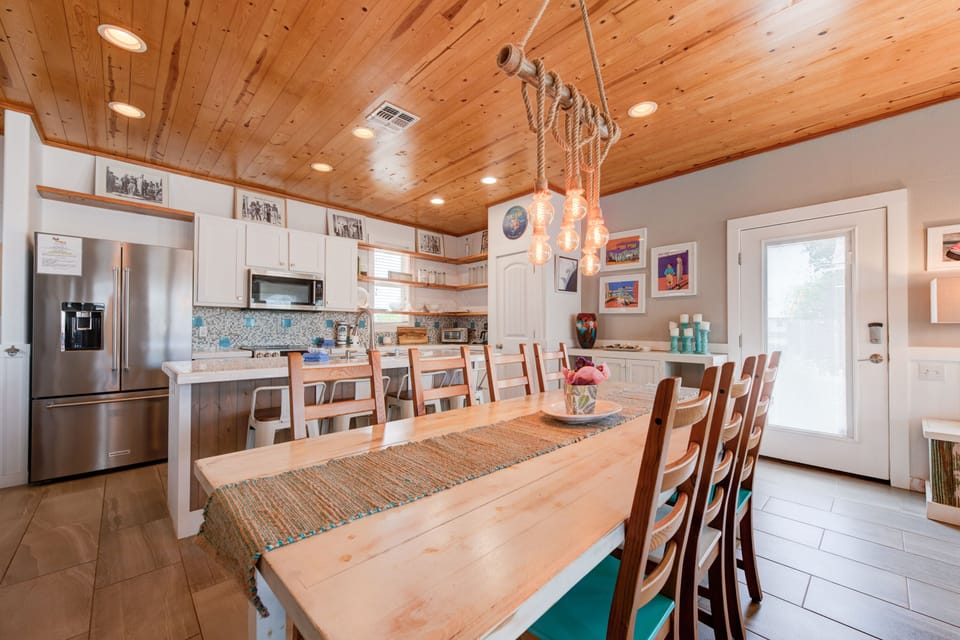 Gather around this warm wooden table where your group can share meals under the rustic rope chandelier, creating perfect moments together.