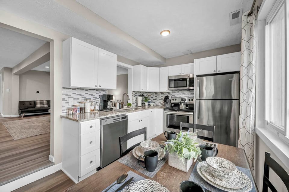 Spacious kitchen w/ stainless steel appliances, white cabinets & plenty of counter space.
