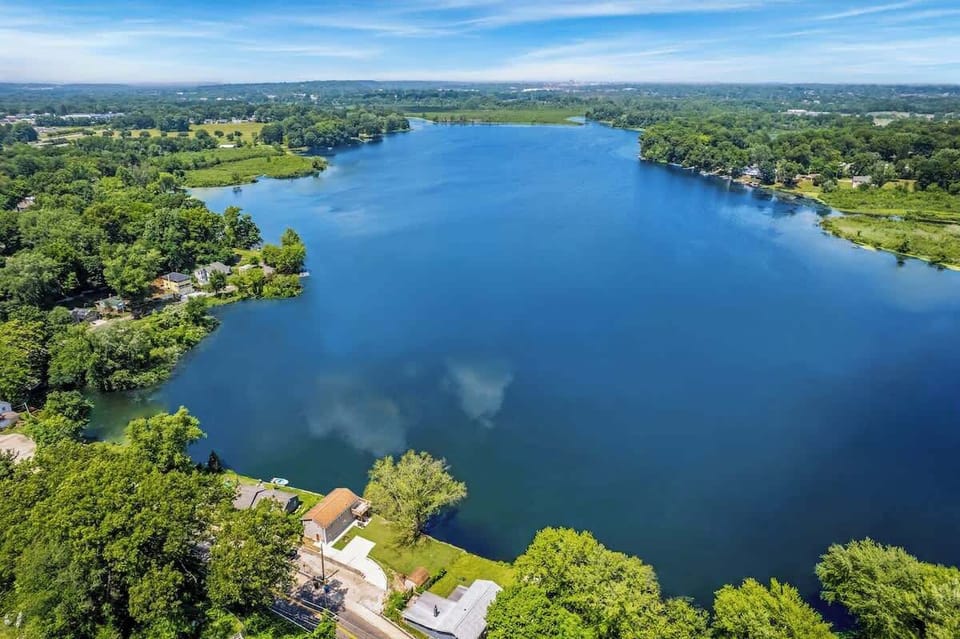 Stunning aerial view showcasing the peaceful lake & surrounding greenery
