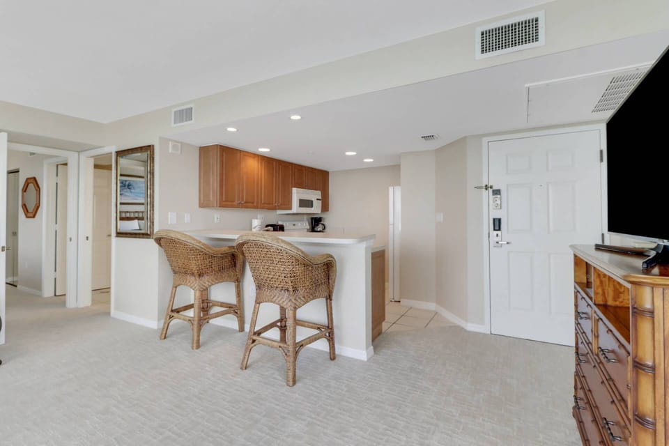 An eating bar with 2 bar stools separates the kitchen from the living area.