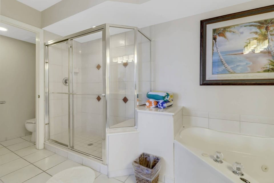 The bathroom also features a large walk-in shower and extended vanity; the toilet is separate by a pocket door.
