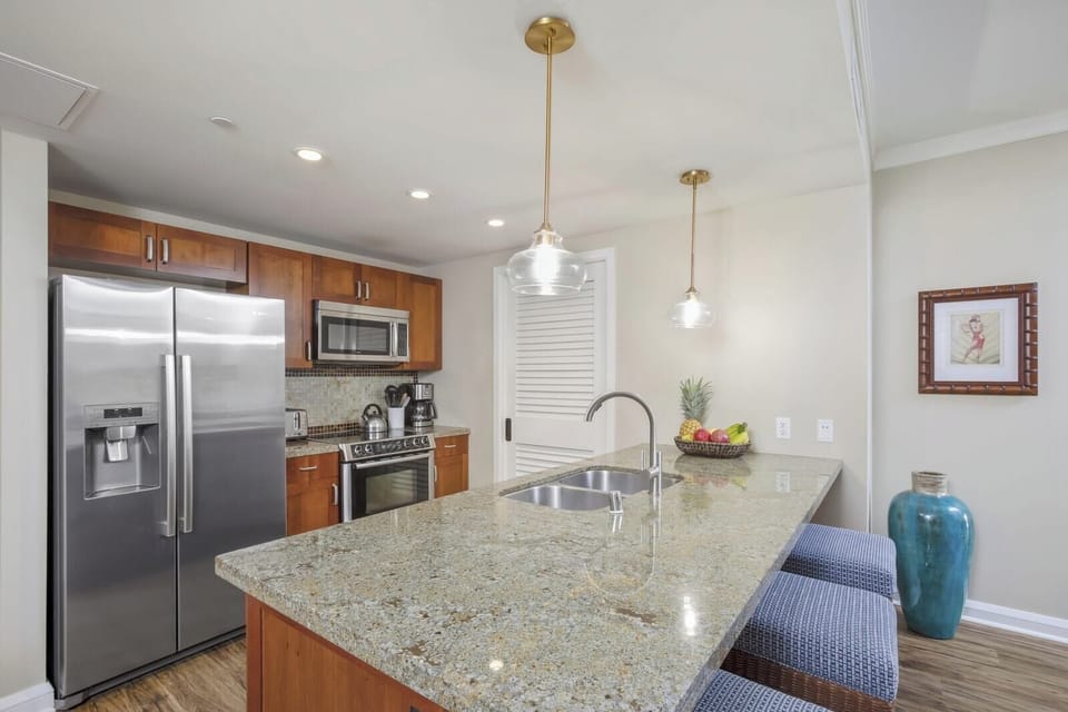 Granite countertops, stainless appliances, and pendant lights complete gourmet kitchen.