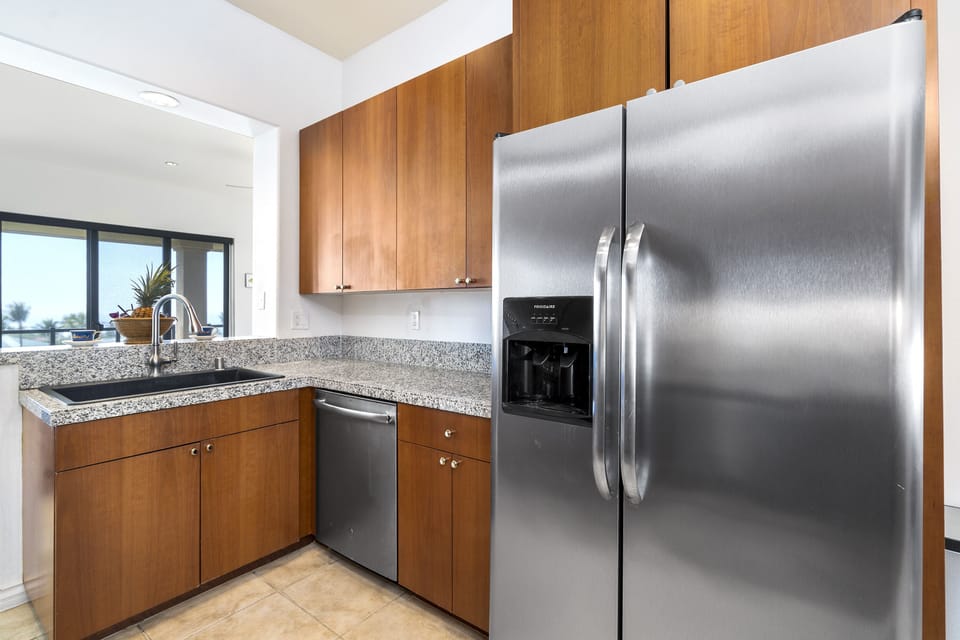 Full kitchen with breakfast bar, granite counters, and stainless steel appliances