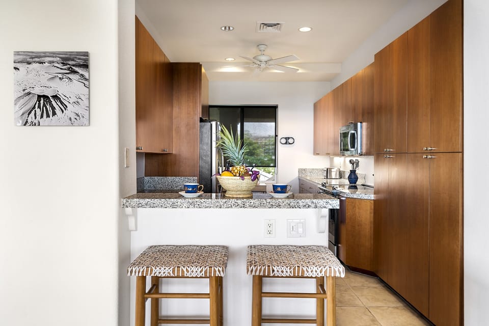 Full kitchen with breakfast bar, granite counters, and stainless steel appliances