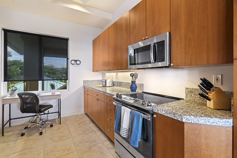 Full kitchen with breakfast bar, granite counters, and stainless steel appliances