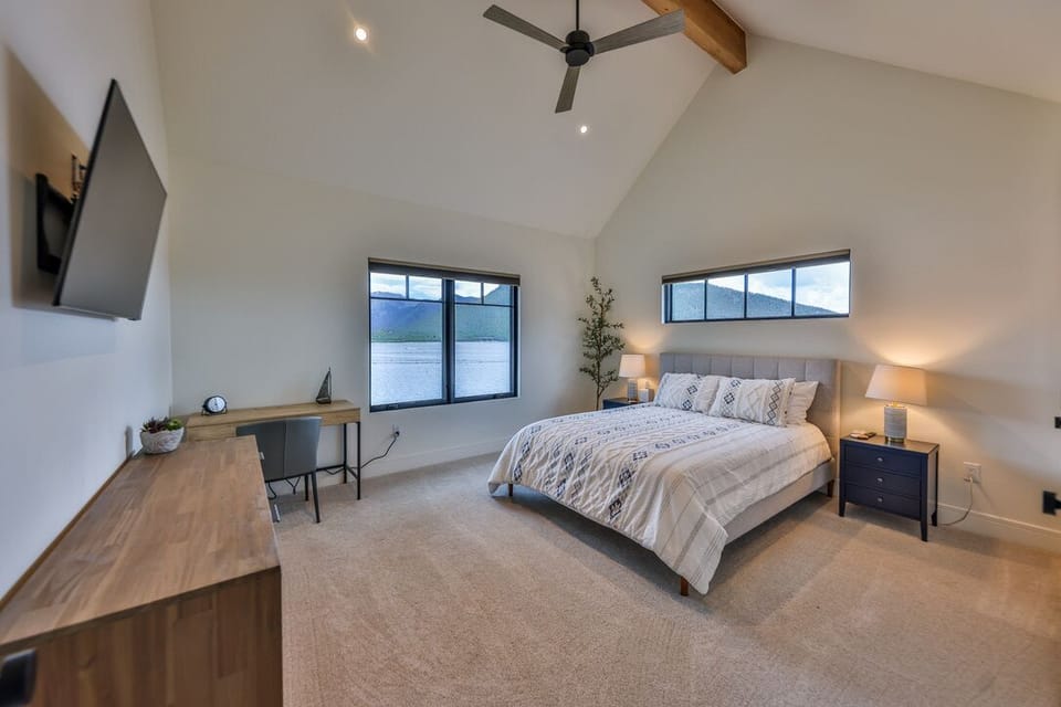 Upstairs bedroom with a desk and queen-sized bed. 