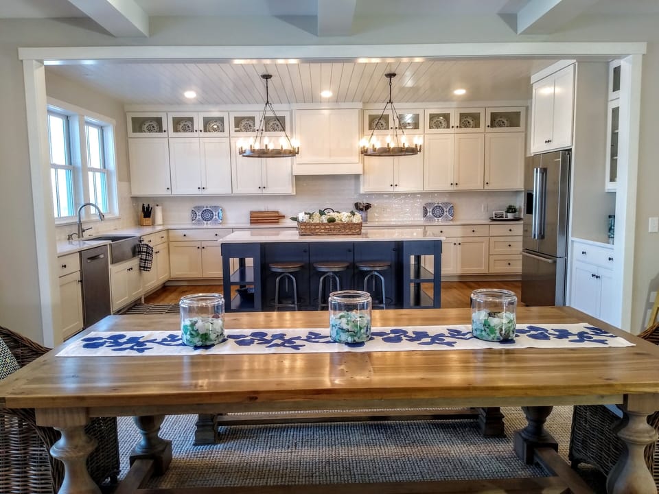 Generous kitchen with large blue island and quartz top.