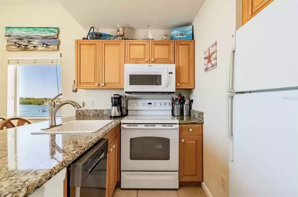 Kitchen with utensils, microwave, oven, stovetop, dishwasher and coffee maker.