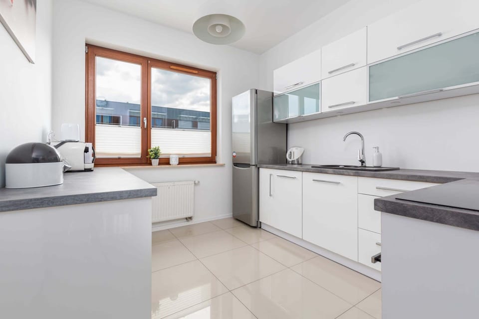Modern kitchen with white cabinetry, ample counter space, and natural lighting.

