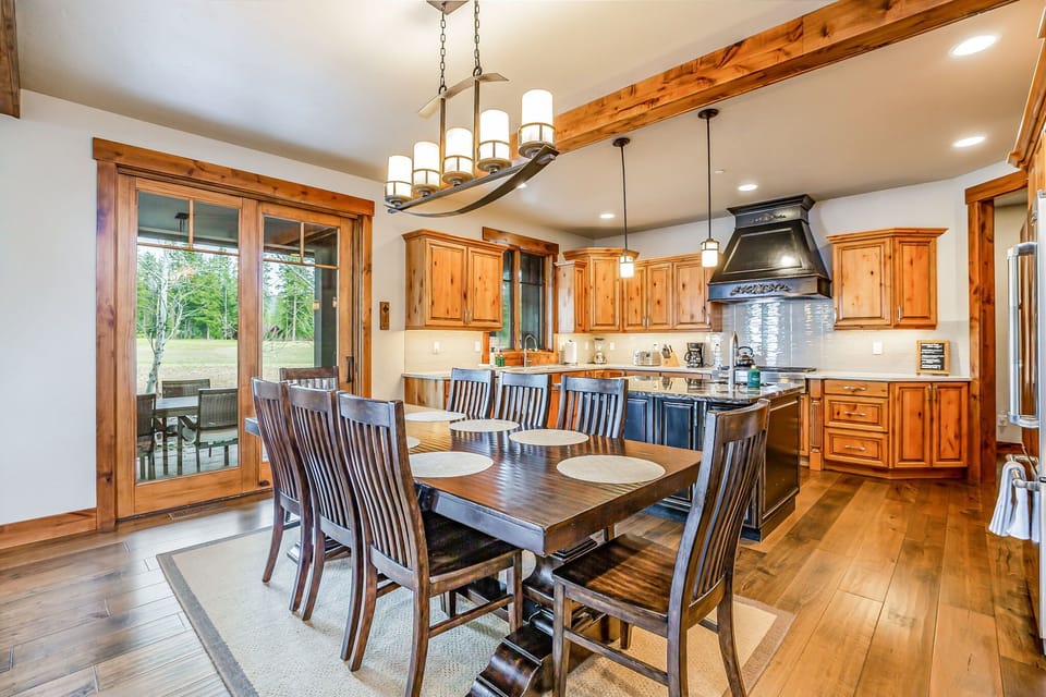 Bright dining area with panoramic windows and artisan chandelier detail