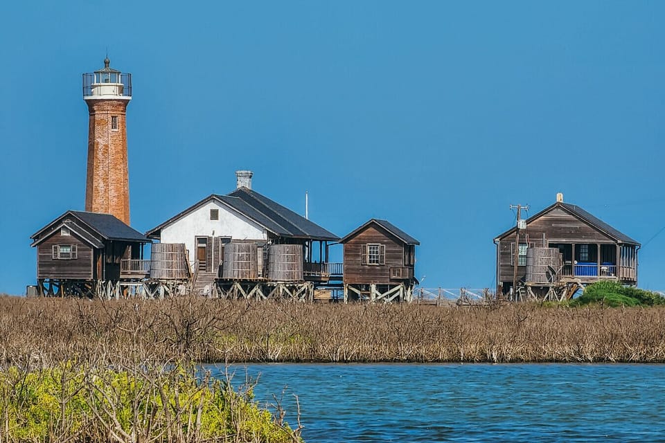 A picturesque coastal landmark where history meets the sea—iconic lighthouse views surrounded by charming waterfront cottages and endless blue skies.