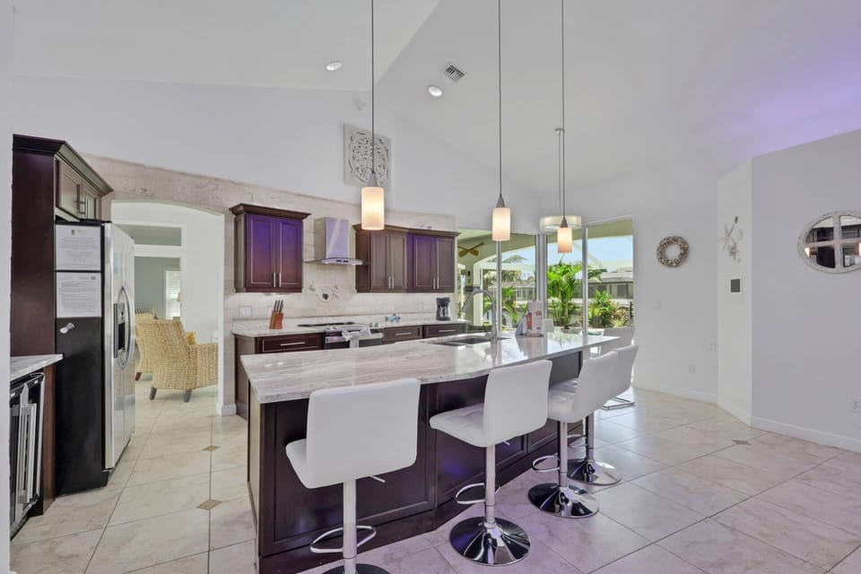 The kitchen features an eating island with barstool seating, granite counters and upgraded appliances.