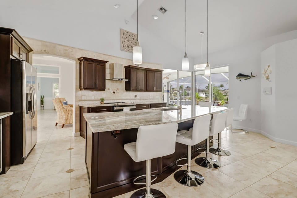 The kitchen features an eating island with barstool seating, granite counters and upgraded appliances.
