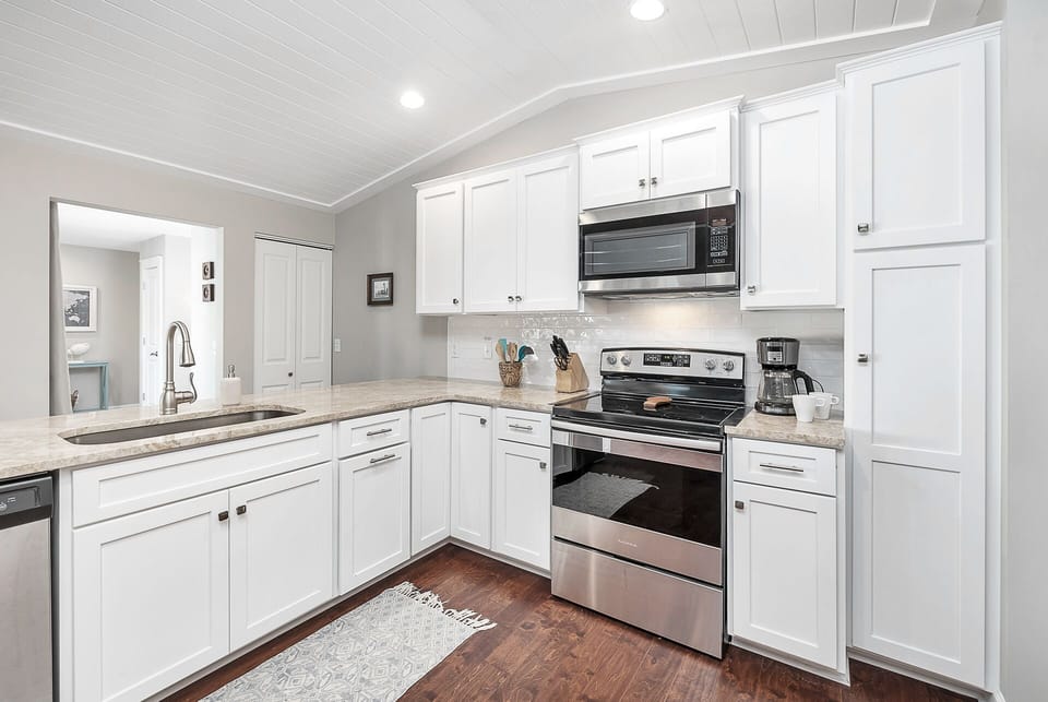 Bright, open Kitchen with white cabinets and stainless steel appliances