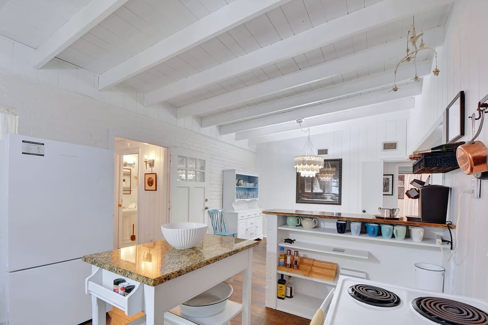 Kitchen View – Island, Dining & Open Flow - From pour-over to pancakes, this bright Jekyll Island kitchen keeps you connected to the conversation. Bonus points for the vintage stove and a direct sightline to that chandelier.