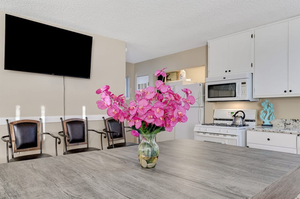 Living room 2 includes a kitchenette, leather couch, extra seating, a desk, 86 inch tv with Youtube TV, and a large dining table. The dining table converts to a pool table and ping pong table.
