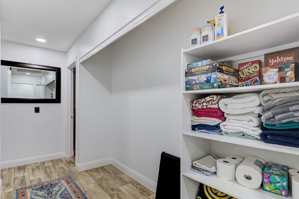 Hallway between bedrooms has board games, sunscreen, extra toiletries, extra towels