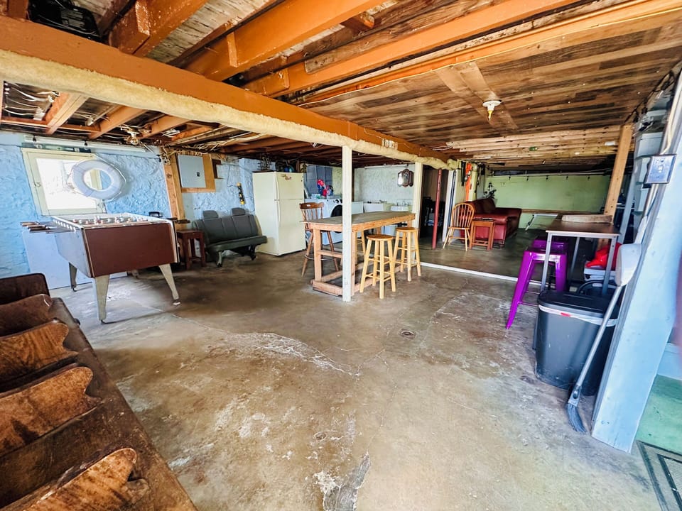 Basement features foosball, bar area, refrigerator, laundry & bathroom