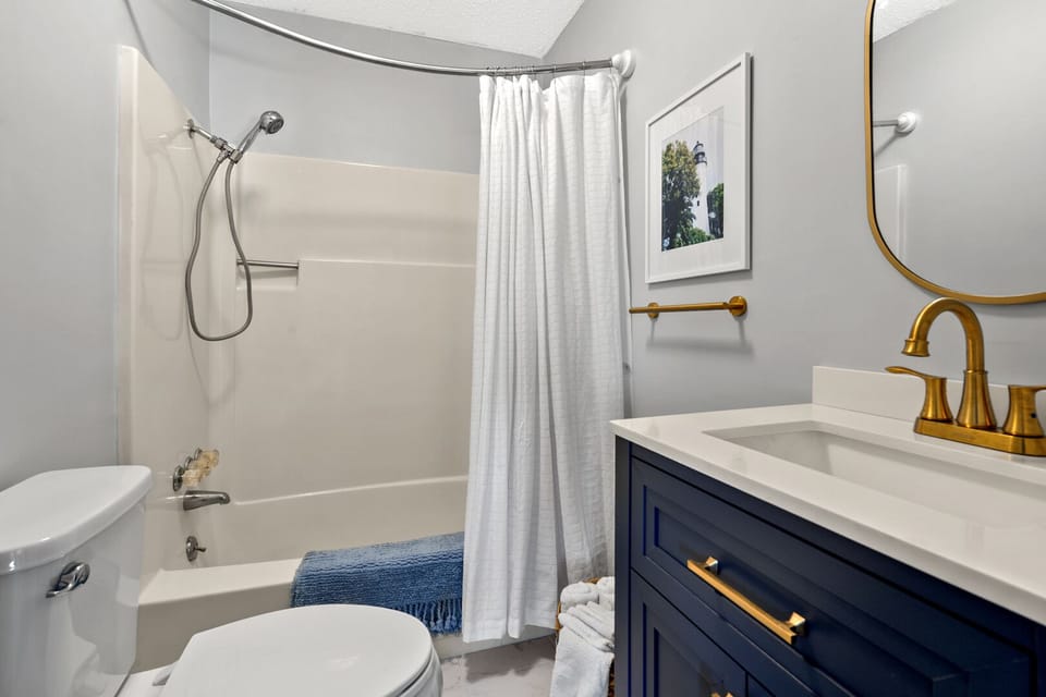 Shower, vanity and gold fixtures in a bathroom at The Gritz Carlton in Cherry Grove