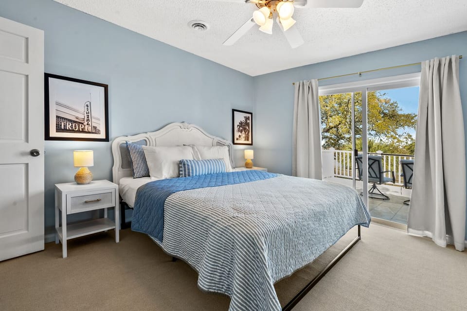 Bedroom with striped bedding and a door to the balcony at The Gritz Carlton, a 3-bedroom rental