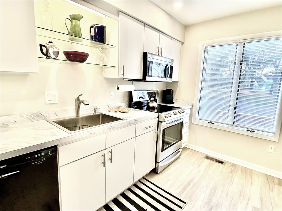 Fully equipped kitchen — stainless steel appliances, breakfast bar, and everything you need to whip up a local Delaware seafood feast.