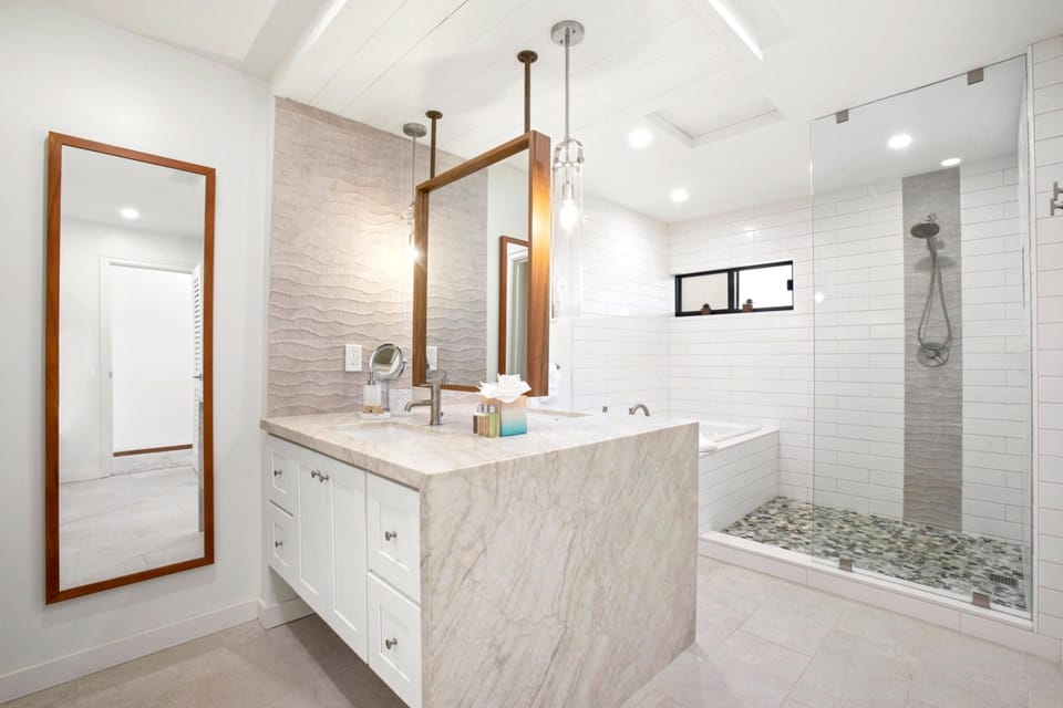  The double vanity with a polished marble surface and bronze-accented mirrors offers both style and functionality   