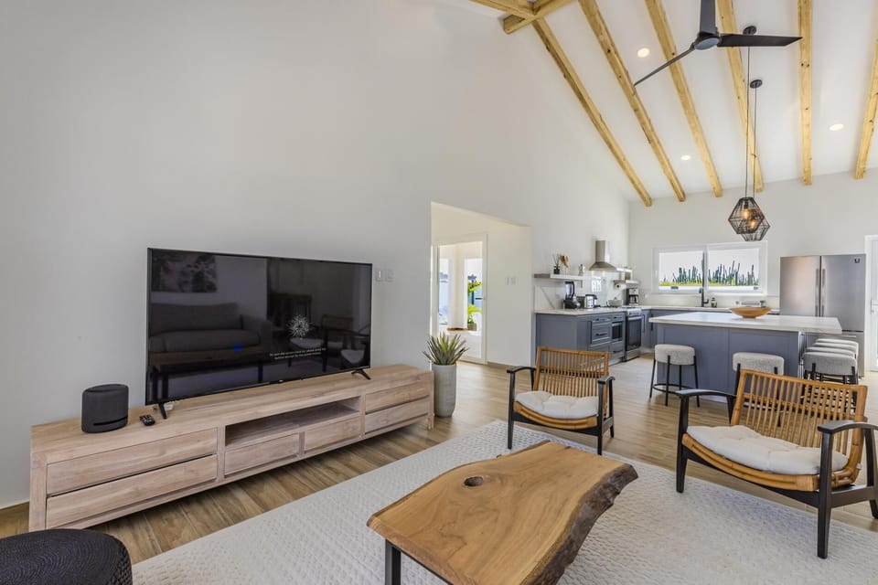The living room features exquisite chairs and a sofa. There is a smart tv and it is fully  air-conditioned