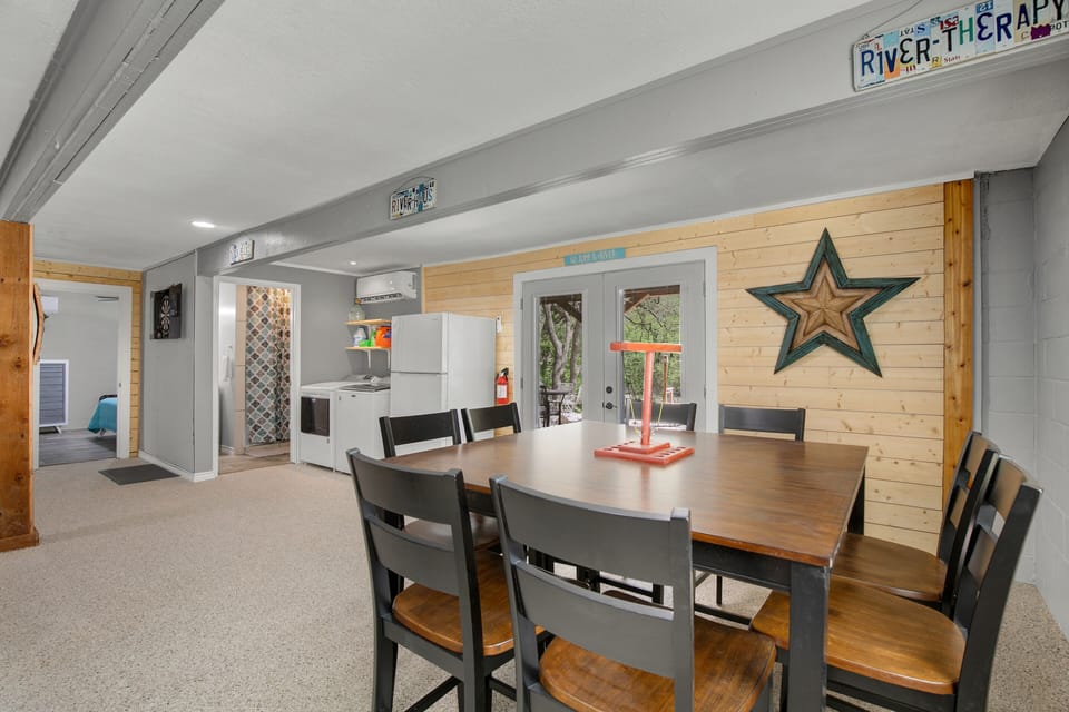 Huge table downstairs with French Doors leading out to covered seating and patio