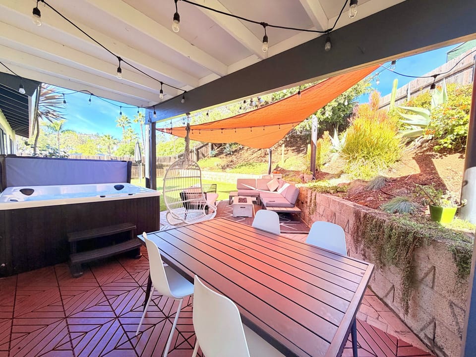 Private backyard with hot tub, dining table, lounge with fire pit, and BBQ Grill