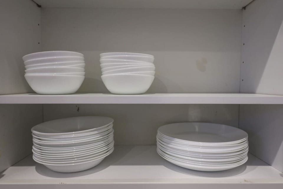 Kitchen cabinet with white bowls and plates neatly stacked