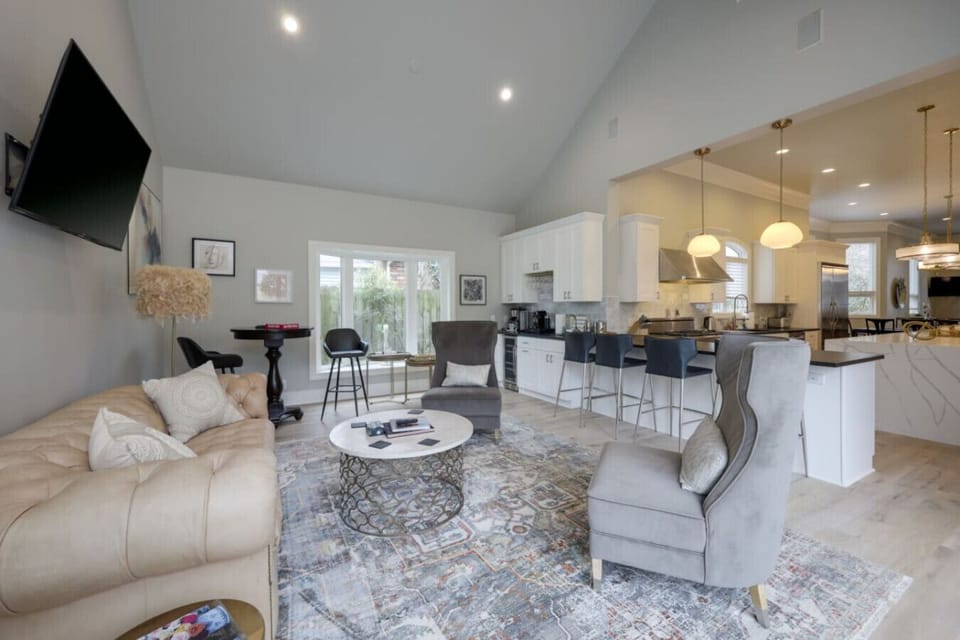 Open living and dining area with a sofa, kitchen island visible in the background