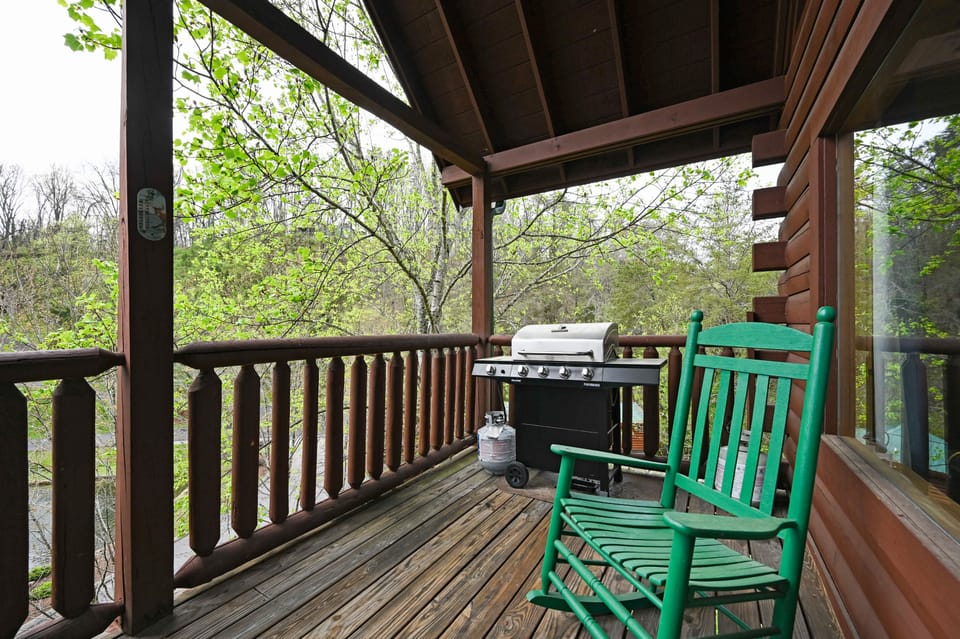 A propane grill and rocking chairs on the deck.