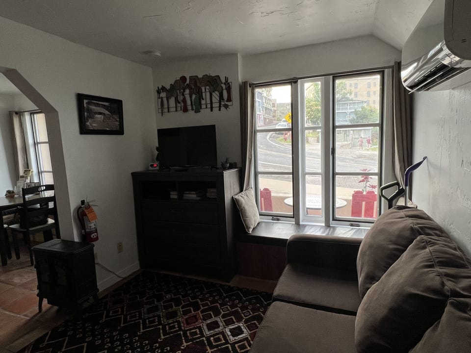 View of living room from the bed. Pull out couch, tv, and dresser.
