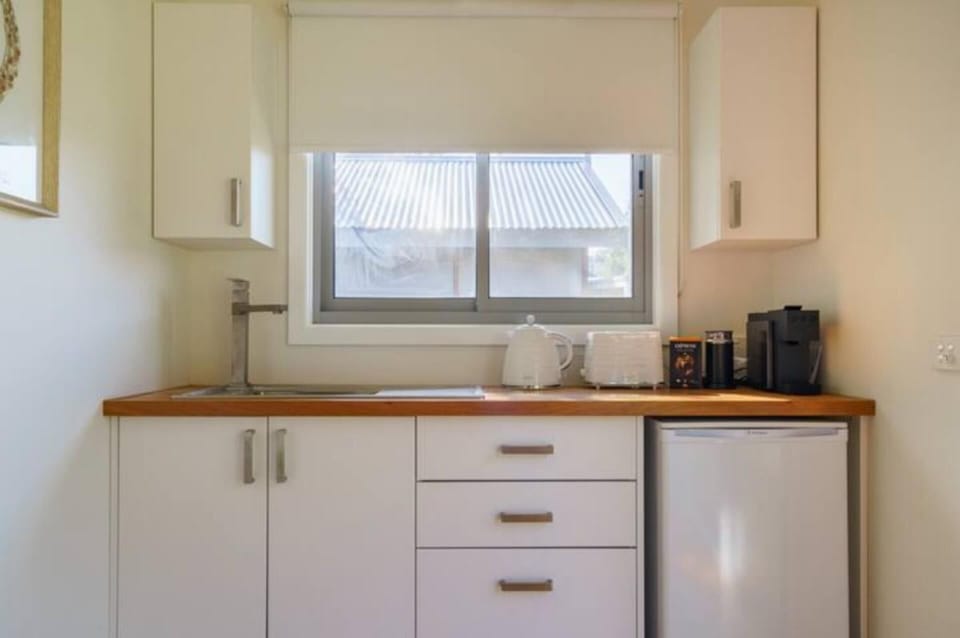 Studio kitchenette with coffee pod machine, kettle, toaster, fridge and sink