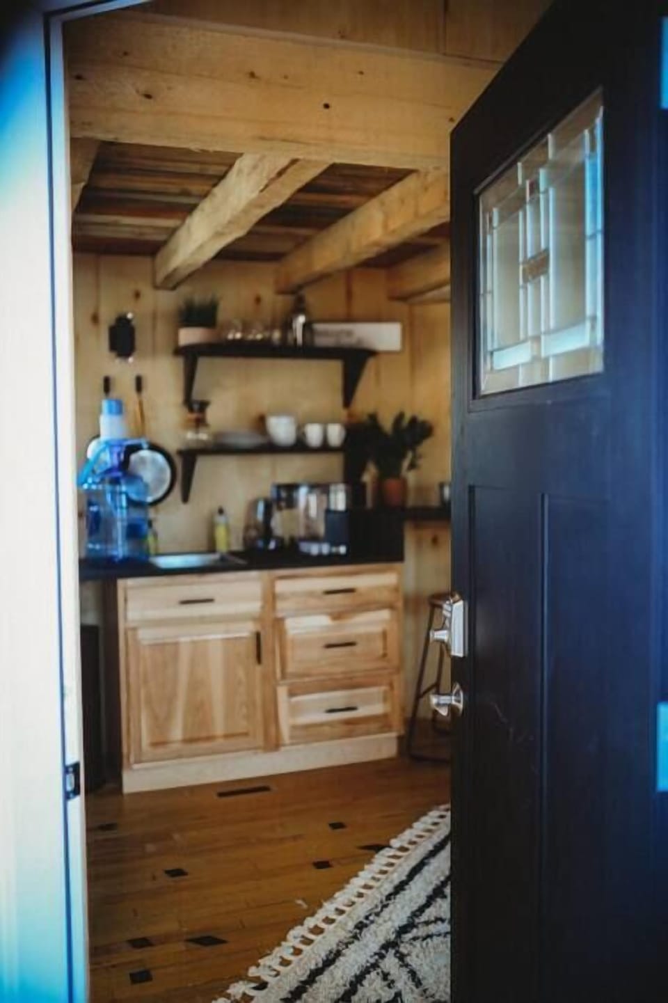 Step inside a charming retreat featuring a rustic yet modern kitchenette, warm wood finishes, and all the comforts for a relaxing getaway in Alaska.