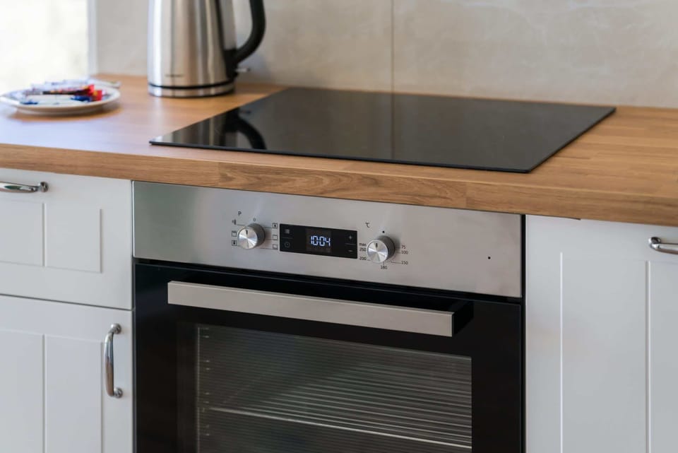 Kitchenette with oven and refrigerator. 