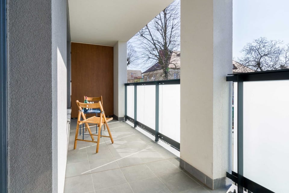 Spacious balcony with outdoor furniture. 