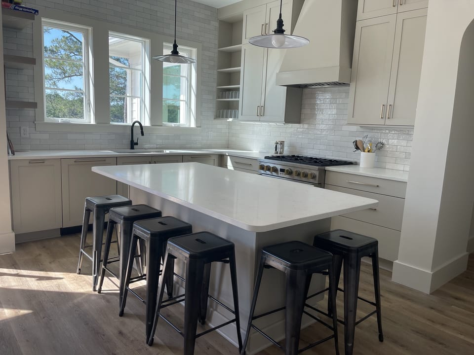 Professional kitchen- 6-burner gas stove and two dishwashers. Island seats six.