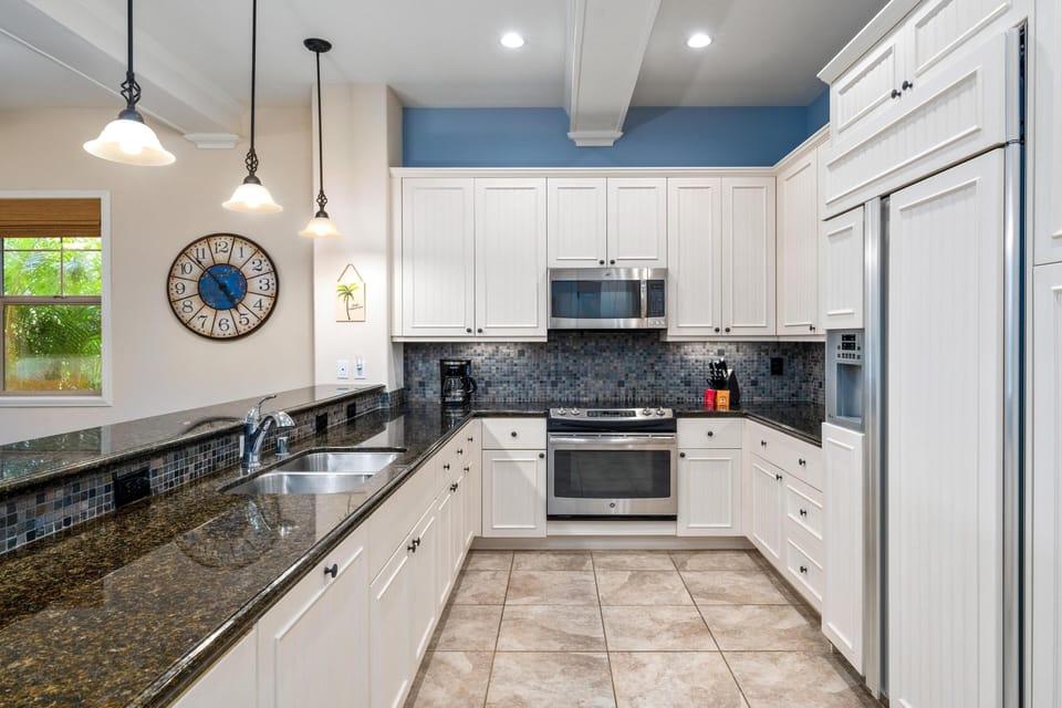 Full kitchen with breakfast bar, granite counters, and stainless steel appliances
