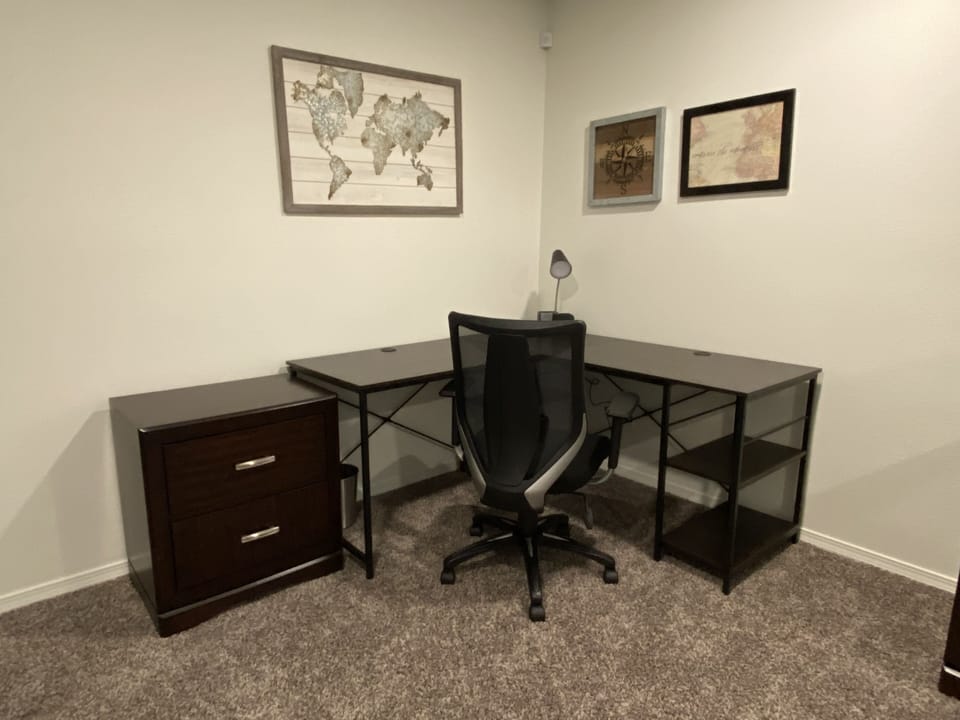Second floor living area work space large with L-shaped desk.
